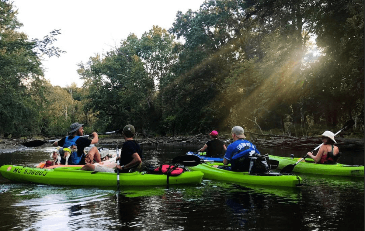 Group kayaking trip on the river with River Town Adventures